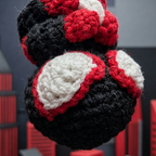Crocheted boxing glove ornament hanging against a dark background